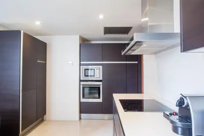 a kitchen with stainless steel appliances and black cabinets at Majestic Hotel & Spa Barcelona GL in Barcelona