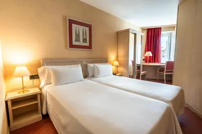 a hotel room with a large white bed with two pillows at Sunotel Junior in Barcelona