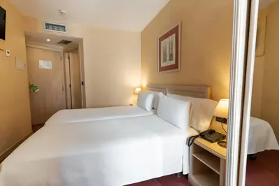 a bedroom with a large white bed and a telephone at Sunotel Junior in Barcelona