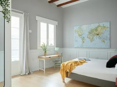 a bedroom with a bed and a desk with a map on the wall at Casa Cosi Patio 1 in Barcelona