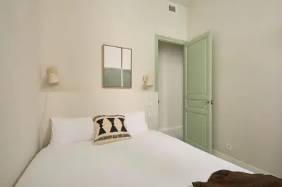 a bedroom with a white bed and a green door at Casa Cosi Don Bajos in Barcelona