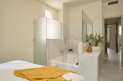 a white bathroom with a tub and a bed and a sink at Casa Cosi Don Bajos in Barcelona