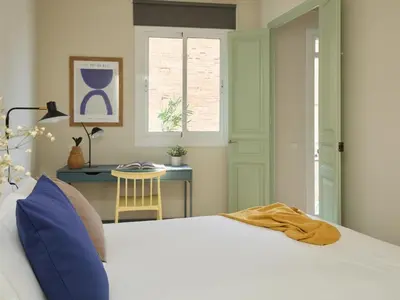 a bedroom with a white bed and a desk at Casa Cosi El Farro 4 in Barcelona