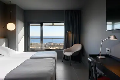 a hotel room with a bed and a desk and a window at Barcelona Princess in Barcelona
