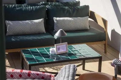 a living room with a green couch and a table at Via Sants Hotel Barcelona, Tapestry Collection By Hilton in Barcelona