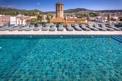 a swimming pool with chaise lounges and avisor at Mercè in Pineda de Mar