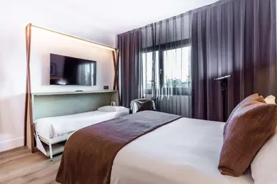 a hotel room with two beds and a tv at Best Western Plus Hotel Alfa Aeropuerto in Barcelona