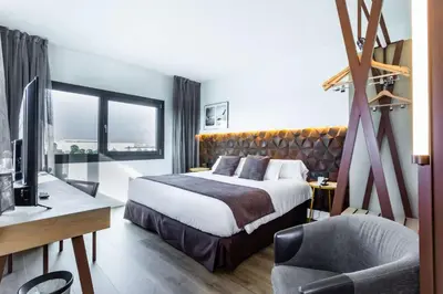 a hotel room with a bed and a desk and a chair at Best Western Plus Hotel Alfa Aeropuerto in Barcelona