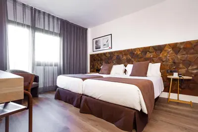 a bedroom with a large bed with a large headboard at Best Western Plus Hotel Alfa Aeropuerto in Barcelona
