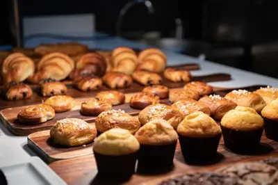 a bunch of donuts and muffins on a table at Catalonia Barcelona Beach in Barcelona