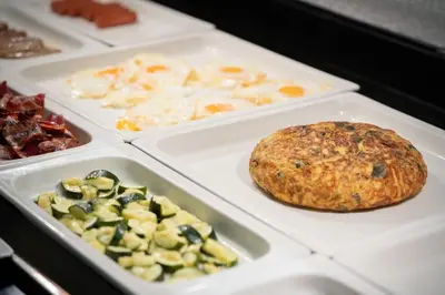 a table with trays of different types of food at Catalonia Barcelona Beach in Barcelona