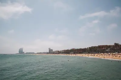 a beach with a group of people in the water at Catalonia Barcelona Beach in Barcelona