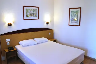 a bedroom with a large white bed with two pillows at Travelodge Barcelona del Vallés in Barbera del Valles