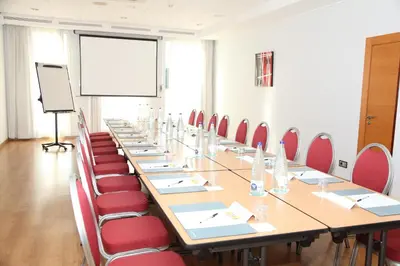 a conference room with a long table and red chairs at Travelodge Barcelona del Vallés in Barbera del Valles