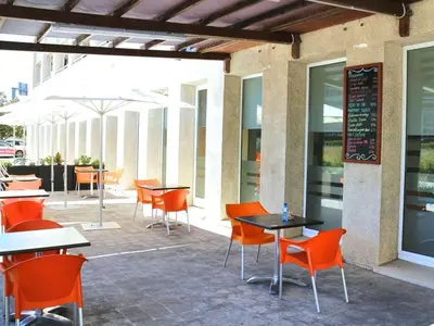 an outdoor patio with tables and chairs and a chalkboard at Travelodge Barcelona del Vallés in Barbera del Valles