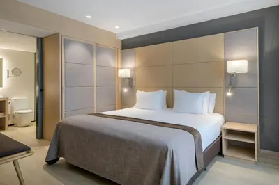 a hotel room with a large bed with white pillows at AC Hotel Victoria Suites by Marriott in Barcelona