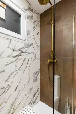 a bathroom with a shower with a tv on the wall at apartamento con calefaccion y parkig privado gratis in Badalona