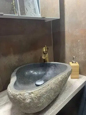 a bathroom with a stone sink on a counter at apartamento con calefaccion y parkig privado gratis in Badalona