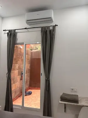a bedroom with a sliding glass door with a window at apartamento con calefaccion y parkig privado gratis in Badalona