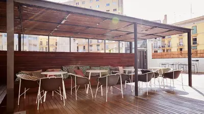 a restaurant with tables and chairs on a deck at TOC Hostel Barcelona in Barcelona