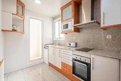 a kitchen with white appliances and a window at Apartaments Marina - Abapart in Barcelona