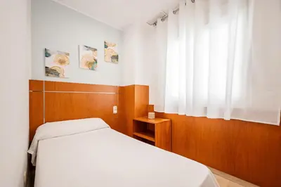 a bedroom with a white bed and a window at Apartaments Marina - Abapart in Barcelona