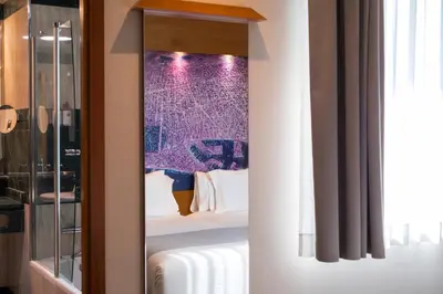 a bedroom with a bed and a purple wall at Abba Sants in Barcelona