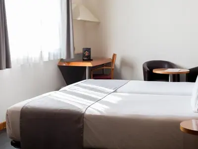 a hotel room with a bed and a table and chairs at Abba Sants in Barcelona
