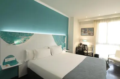 a bedroom with a large white bed and a window at Hotel Concordia Barcelona in Barcelona