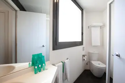 a white bathroom with a sink and a toilet at Hotel Concordia Barcelona in Barcelona