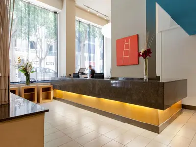 a lobby with a reception desk and large windows at Hotel Sagrada Familia in Barcelona