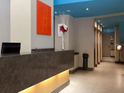 a lobby with a reception counter with a vase of flowers at Hotel Sagrada Familia in Barcelona