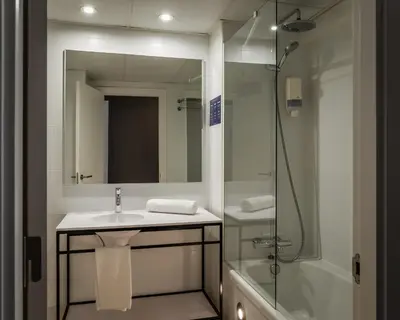 a bathroom with a sink and a shower with a mirror at Hotel Sagrada Familia in Barcelona