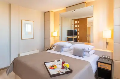 a hotel room with a large bed with a tray of food on it at Hesperia Barcelona Presidente in Barcelona