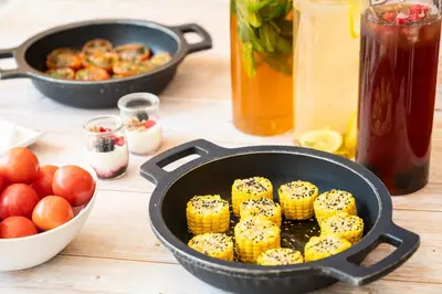 a pan filled with corn on the cob next to apples at Hesperia Barcelona Presidente in Barcelona