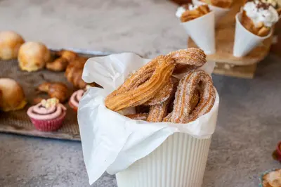 a paper cup filled with pretzels and a tray of pastries at Hesperia Barcelona Presidente in Barcelona