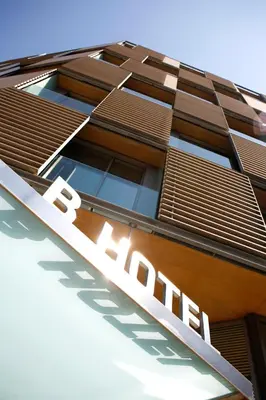 a patio with tables and chairs on a roof at B Hotel in Barcelona