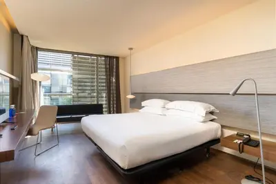 a hotel room with a large bed and a desk and a desk at B Hotel in Barcelona