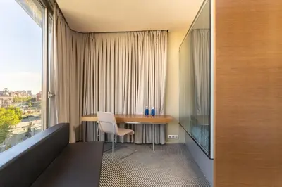 a bed with a white pillow and a light at B Hotel in Barcelona
