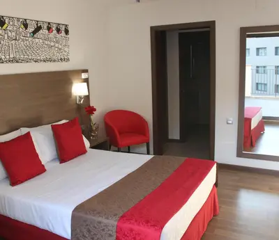 a hotel room with a bed and a red chair at Hotel Best Auto Hogar in Barcelona