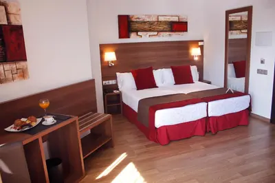 a hotel room with a large bed and a table at Hotel Best Auto Hogar in Barcelona