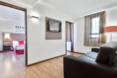 a living room with a couch and a mirror at Hotel Best Auto Hogar in Barcelona