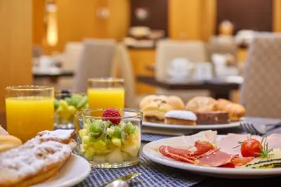 a table with plates of breakfast foods and orange juice at Eurostars Monumental in Barcelona