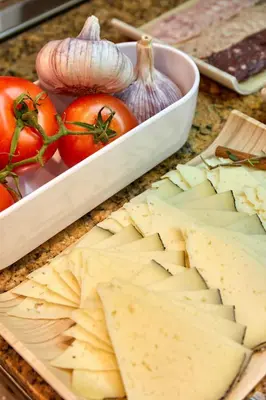 a table with a tray of cheese and tomatoes at Eurostars Monumental in Barcelona