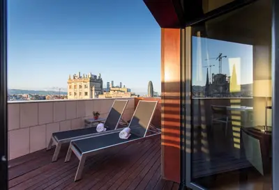 a balcony with two benches and a view of a city at Eurostars Monumental in Barcelona