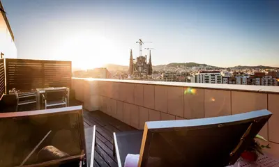 a balcony with tables and chairs and a view of a city at Eurostars Monumental in Barcelona