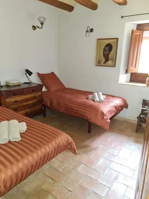 a bedroom with two beds and a dresser and a window at Cal Colina - Karaktervol landhuis met privé zwembad in Pacs del Penedes