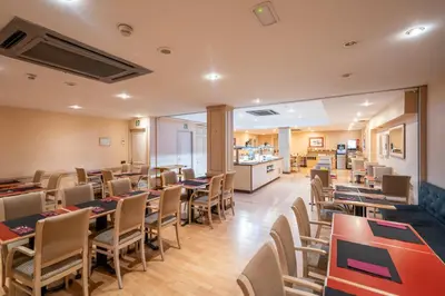 a restaurant with tables and chairs and a kitchen at Sunotel Aston in Barcelona