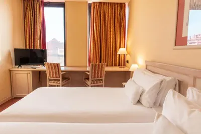a hotel room with a bed and a desk with a computer at Sunotel Aston in Barcelona
