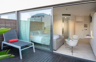 a balcony with a bedroom and a bed and a chair at Cram Hotel in Barcelona
